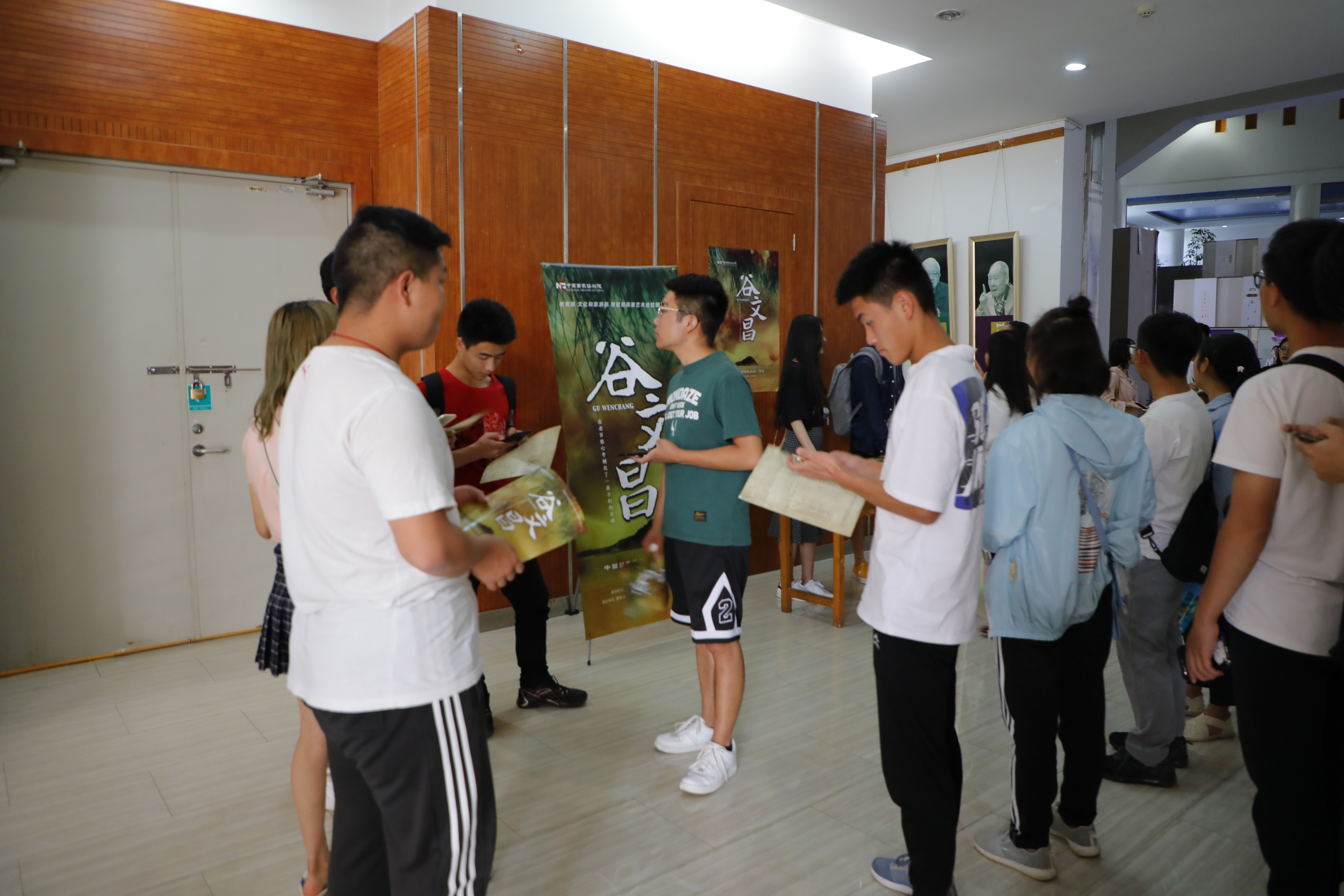 学生等待入场时阅读宣传页